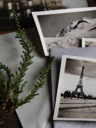 Vieilles photos en noir et blanc avec une vue de la Tour Eiffel, symbolisant les souvenirs familiaux pour des recherches généalogiques